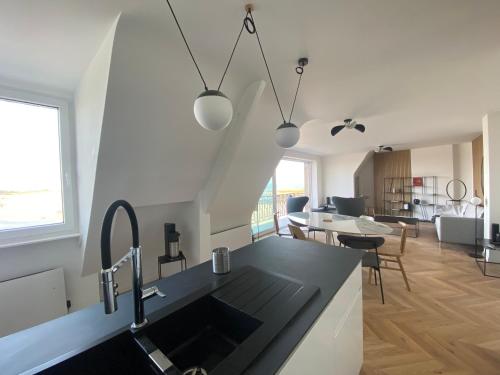 a kitchen with a sink and a living room at Villa Ster et Mer in Plobannalec-Lesconil