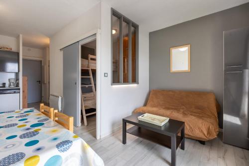 une petite chambre avec un lit et une table dans l'établissement Zénitude - Appartement au pied des pistes, aux Angles