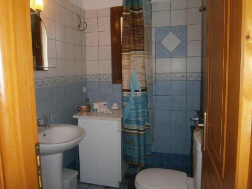 La petite salle de bains est pourvue d'un lavabo et de toilettes. dans l'établissement Moraki Apartment, à Episkopión
