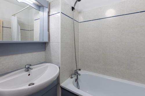 une salle de bain avec une baignoire blanche et un lavabo dans l'établissement Zénitude - Appartement au pied des pistes, aux Angles