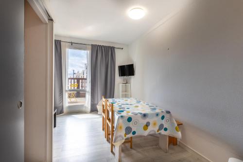une salle à manger avec une table et des chaises et une fenêtre dans l'établissement Zénitude - Appartement au pied des pistes, aux Angles