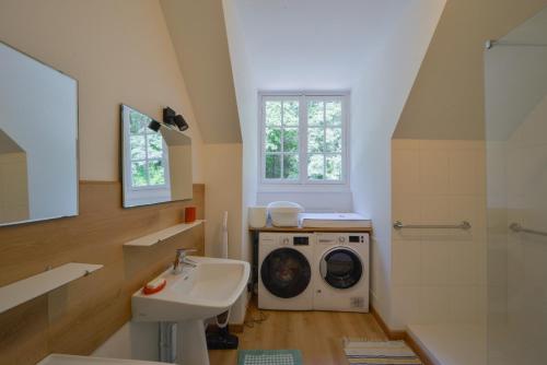W łazience znajduje się pralka i umywalka. w obiekcie La Genêtière - Grande maison avec étang en Sologne w mieście Méry-ès-Bois