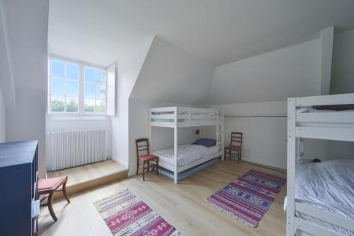 a room with two bunk beds and two chairs at La Genêtière - Grande maison avec étang en Sologne in Méry-ès-Bois