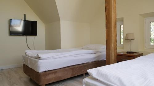 two beds in a room with a tv on the wall at Szewczenki 3 in Olsztyn
