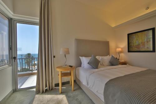 a bedroom with a bed and a large window at Riviera Hotel and Beach Lounge, Beirut in Beirut