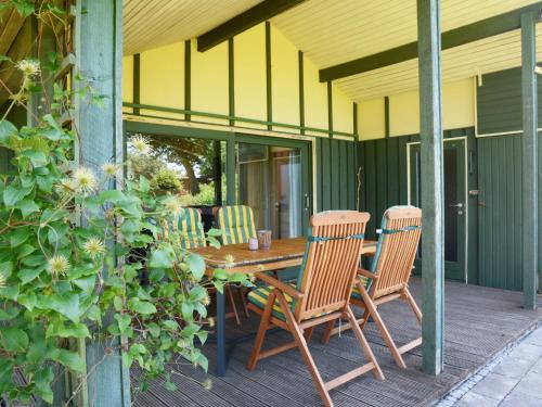 RottにあるHoliday Home Wiesenhütte by Interhomeの木製テーブルと椅子付きのパティオ