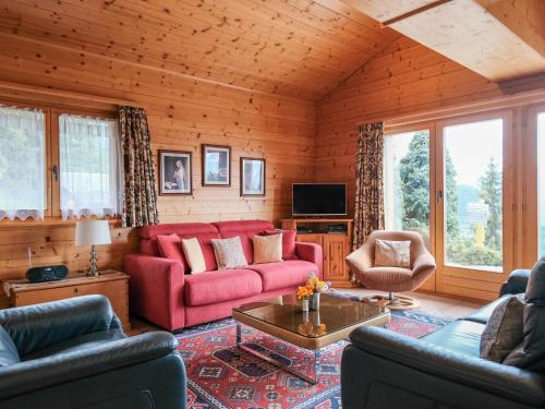 a living room with a red couch and chairs at Chalet Biquinou by Interhome in Verbier