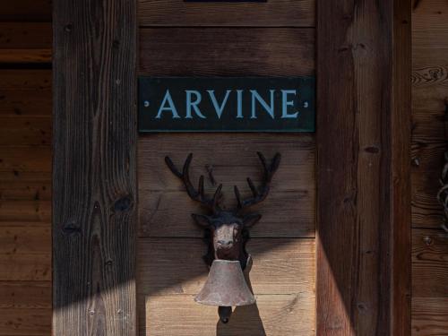 una testa di renna con una campana appesa a un muro di legno di Chalet Chalet Arvine by Interhome a Nendaz