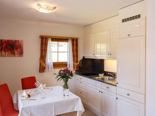 eine Küche mit einem Tisch und einer Blumenvase darauf in der Unterkunft Apartment Allegra Sur 201 by Interhome in Zuoz
