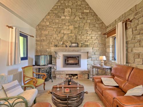 un salon avec un canapé et un mur en pierre dans l'établissement Holiday Home St Adrien by Interhome, à Ploemeur