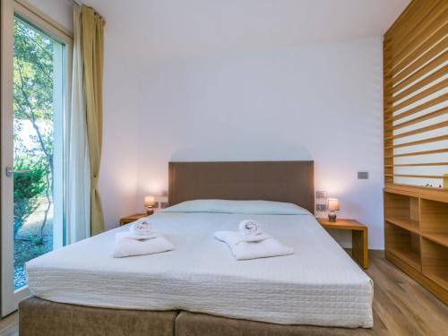 a bedroom with a large bed with towels on it at Holiday Home Biovillage-6 by Interhome in Collemezzano