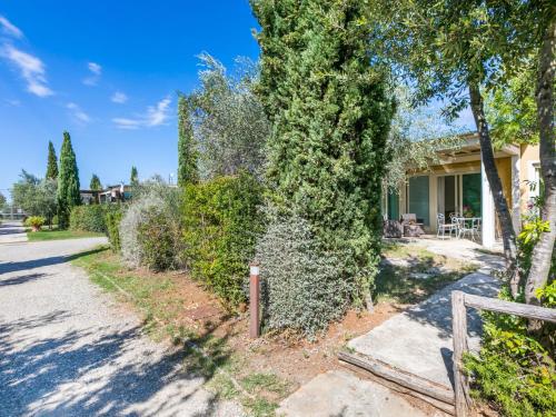 a house with a fence and trees next to a street at Holiday Home Biovillage-6 by Interhome in Collemezzano