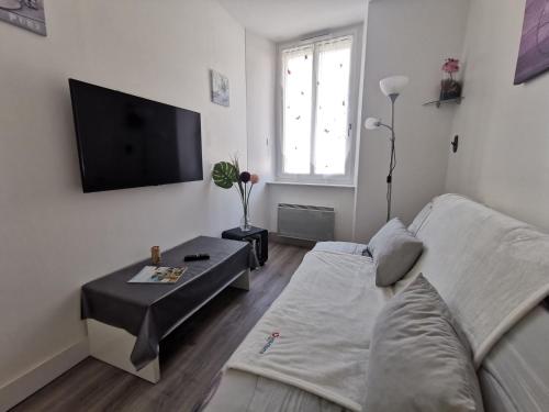a living room with a couch and a flat screen tv at Apartment La Licorne by Interhome in Saint Malo