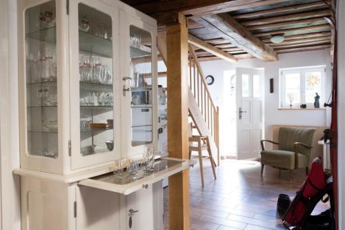 una cocina con un armario blanco con puertas de cristal en Ferienhaus "Am Bodeweg 1" en Schierke