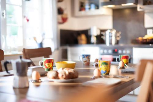 una mesa con huevos y tazas en la cocina en Ferienhaus "Am Bodeweg 1" en Schierke