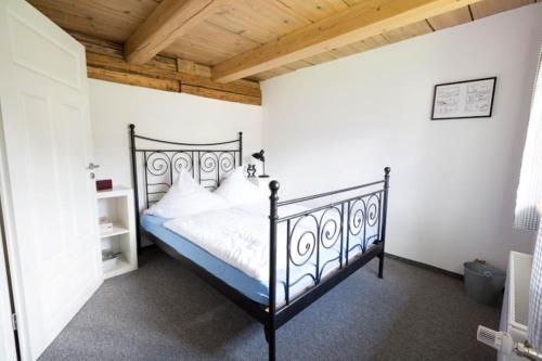 a bedroom with a black bed and a wooden ceiling at Ferienhaus "Am Bodeweg 1" in Schierke