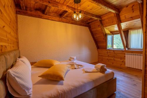 um quarto com uma cama grande num quarto de madeira em Theth Kompleksi Gjoni em Theth