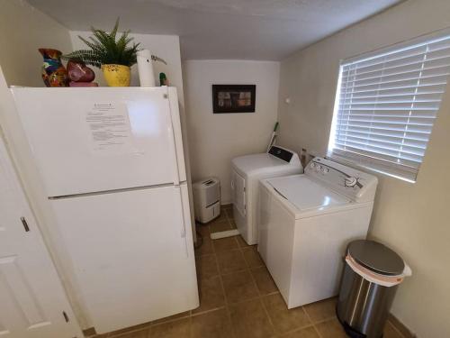 una pequeña cocina con nevera, lavadora y secadora. en Little Garden House, en Pine Mountain