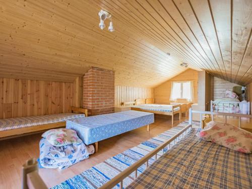 LahdenkyläにあるHoliday Home Otsolaのレンガの壁の広い客室で、ベッド2台が備わります。
