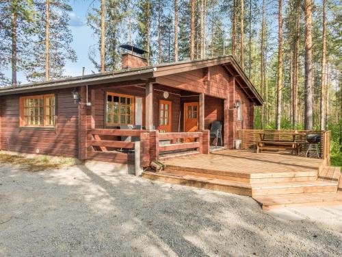 een hut in het bos met een groot houten terras bij Holiday Home Hilla by Interhome in Herttua