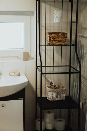 a bathroom with a black shelf next to a sink at Jasminowe Wzgorze in Wilkanów