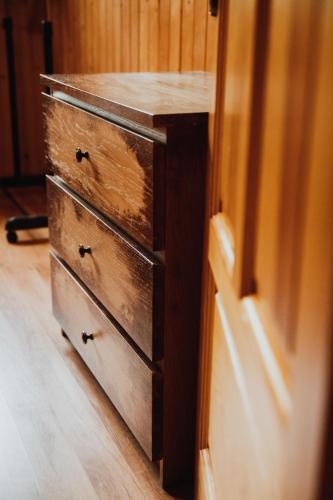 a wooden dresser in a room with a drawer at Jasminowe Wzgorze in Wilkanów