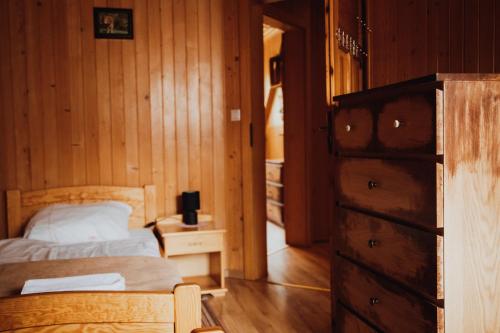 a bedroom with a bed and a dresser in a room at Jasminowe Wzgorze in Wilkanów