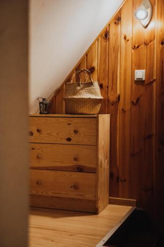 a wooden dresser with a basket on top of it at Jasminowe Wzgorze in Wilkanów