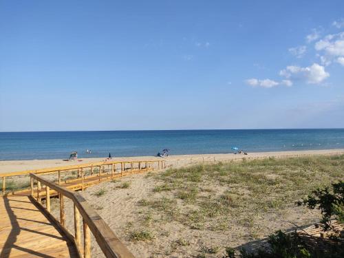 a beach with a wooden fence and people on the beach at DIMORA STORICA ALLA ROTONDA in Mottola