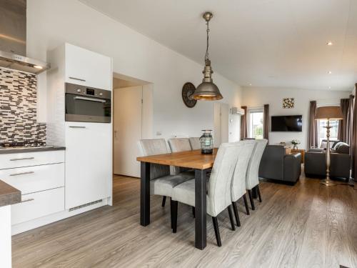 a kitchen and dining room with a wooden table and chairs at Holiday Home Green Resort Mooi Bemelen-1 by Interhome in Bemelen