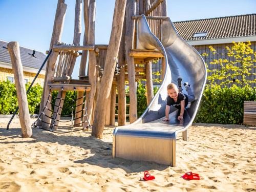 贝梅伦Holiday Home Green Resort Mooi Bemelen-1 by Interhome的操场上滑梯上的男孩