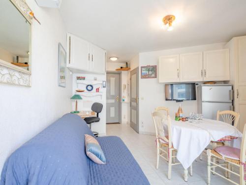 - une cuisine et une salle à manger avec un lit bleu et une table dans l'établissement Apartment Les Rives Latines-1 by Interhome, à Fréjus