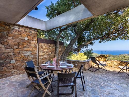 La FavièreにあるHoliday Home Village Les Fourches by Interhomeの海の景色を望むパティオ(テーブル、椅子付)