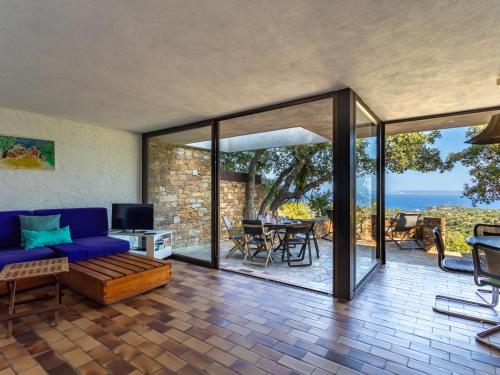 - un salon avec un canapé bleu et des portes coulissantes en verre dans l'établissement Holiday Home Village Les Fourches by Interhome, à La Favière