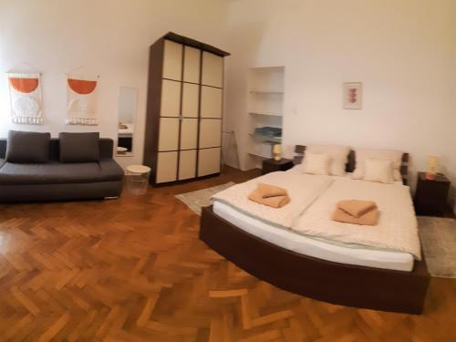 1 dormitorio con 1 cama grande y 1 sofá en Citypark Classic Downtown Apartment, en Budapest