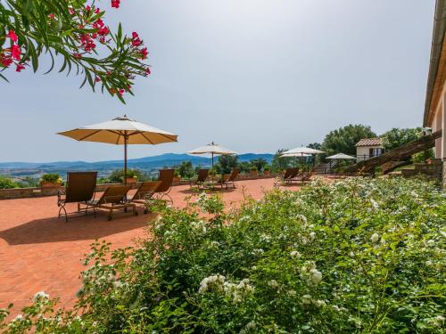 a group of chairs and umbrellas on a patio at Holiday Home Grotte Rosse by Interhome in Cinigiano