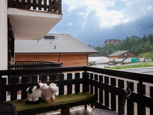 two stuffed animals sitting on a bench on a balcony at Apartment Ecluses 2 by Interhome in Nendaz