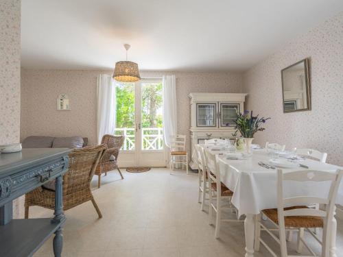 une salle à manger avec une table et des chaises blanches dans l'établissement Apartment Domaine des Fées by Interhome, à Saint-Palais-sur-Mer
