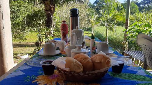una mesa con una cesta de pan encima en Rancho Esperança, pouso e comida a lenha en Parati