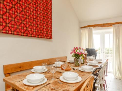SarnにあるHoliday Home Deri'r Mynach by Interhomeのダイニングルーム(白い料理を楽しめる大きな木製テーブル付)