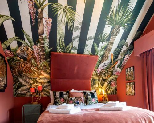 a bedroom with a mural of palm trees on the wall at Trewhiddle Retreat V3 by Together Travel - Luxury 4-Bedroom Villa in St Austell