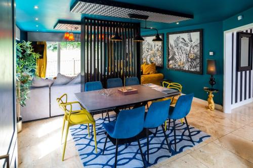 a dining room with a table and blue chairs at Trewhiddle Retreat V3 by Together Travel - Luxury 4-Bedroom Villa in St Austell