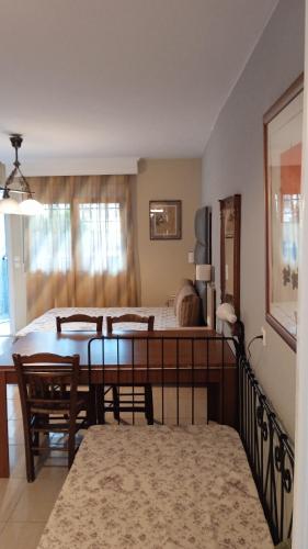 a living room with a dining table and a bedroom at Roses Apartments in Néa Michanióna