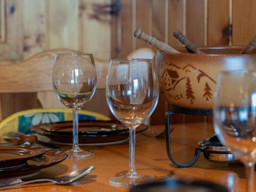 three wine glasses sitting on a wooden table at Studio Christiania I R3 by Interhome in Nendaz
