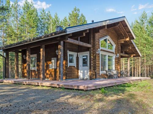a log cabin with a large deck in the woods at Holiday Home Papulantupa by Interhome in Kulho