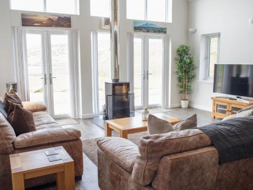 a living room with couches and a flat screen tv at Holiday Home One Mill Lands by Interhome in Uig