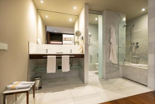 a bathroom with a sink and a shower and a toilet at Hospes Amérigo, Alicante, a Member of Design Hotels in Alicante