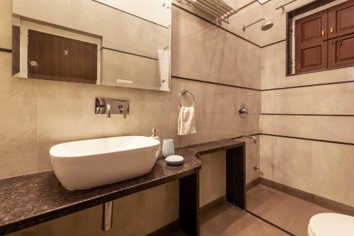 a bathroom with a white sink on a counter at Kanak Vilas by StayVista, a Rajasthani haveli boutique stay with hill views, offering both indoor and outdoor games for a delightful retreat in Jaipur