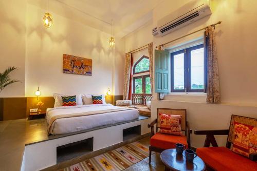 a bedroom with a king sized bed and a window at Kanak Vilas by StayVista, a Rajasthani haveli boutique stay with hill views, offering both indoor and outdoor games for a delightful retreat in Jaipur