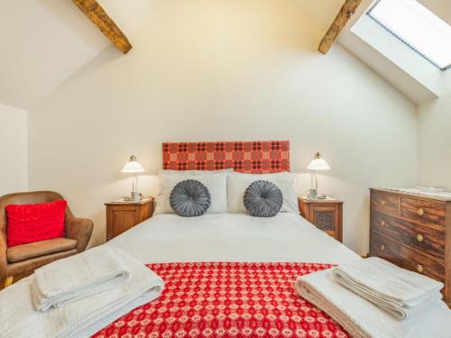 LlandderfelにあるHoliday Home Lyle by Interhomeのベッドルーム1室(赤い敷物付きの大型ベッド1台付)
